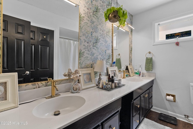 140 One Down St, Southern Pines, NC 28387 - bathroom with double vanity, baseboards, wood finished floors, wallpapered walls, and toilet