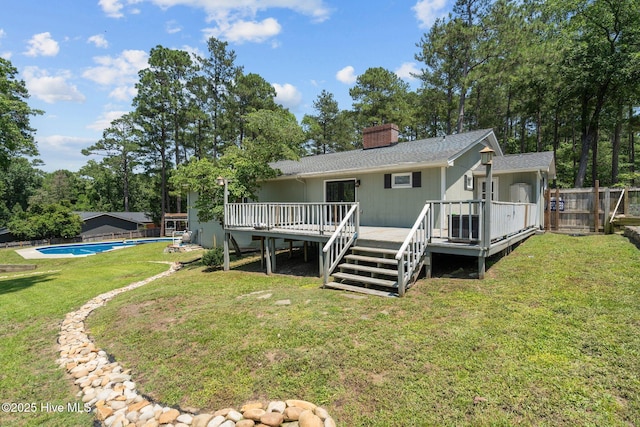 140 One Down St, Southern Pines, NC 28387 - rear view of house featuring a wooden deck, a chimney, an outdoor pool, and a shingled roof