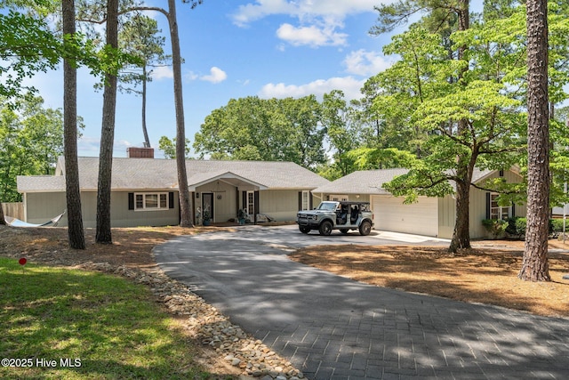 140 One Down St, Southern Pines, NC 28387 - single story home featuring asphalt driveway, an attached garage, roof with shingles, and a chimney