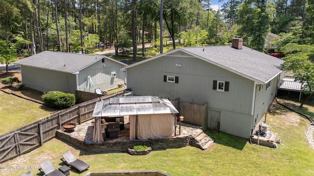 140 One Down St, Southern Pines, NC 28387 - back of house with a chimney, a shingled roof, a deck, and a hot tub