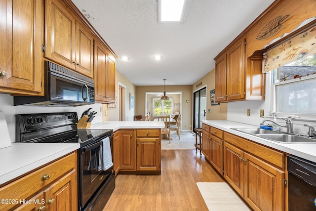 1137 Indigo Cir, Sunset Beach, NC 28468 - kitchen featuring black appliances, a sink, light wood-style floors, brown cabinetry, and recessed lighting