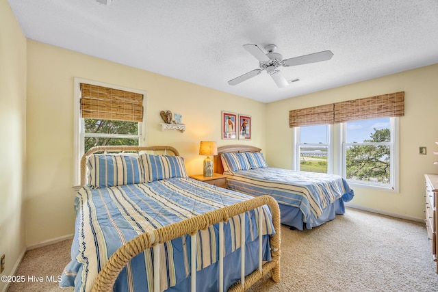 1137 Indigo Cir, Sunset Beach, NC 28468 - carpeted bedroom featuring multiple windows, baseboards, ceiling fan, and a textured ceiling
