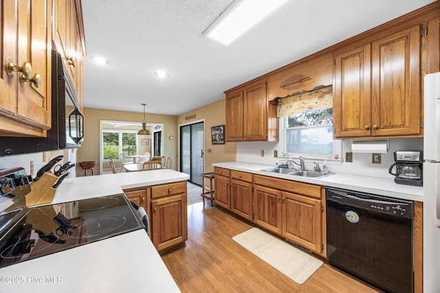1137 Indigo Cir, Sunset Beach, NC 28468 - kitchen with black appliances, a sink, light wood-style floors, brown cabinetry, and recessed lighting