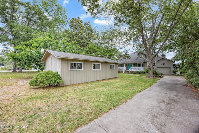 1137 Indigo Cir, Sunset Beach, NC 28468 - view of front of home with an outbuilding, a garage, a front yard, board and batten siding, and concrete driveway