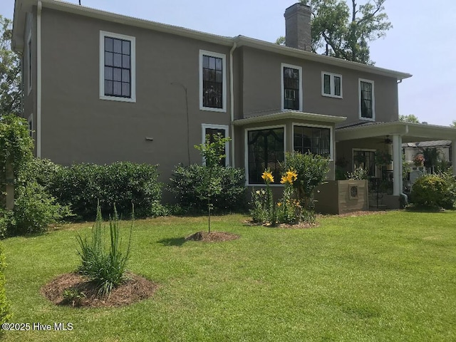 601 Saint Patrick St, Tarboro, NC 27886 - back of property with stucco siding, ceiling fan, a yard, and a chimney