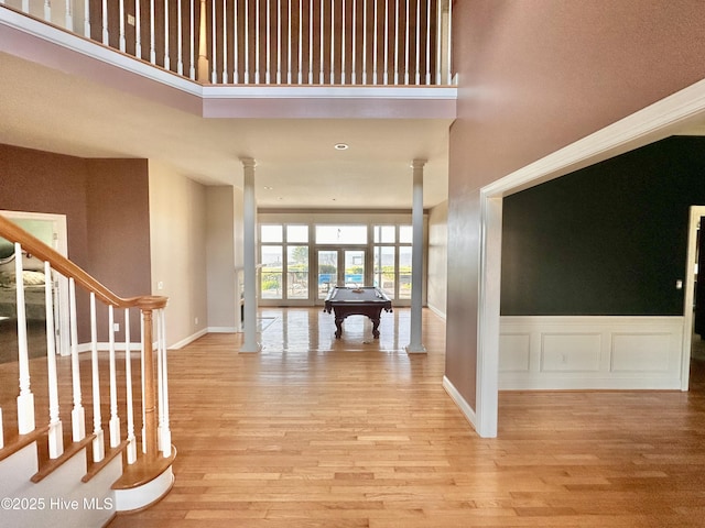141 Baybreeze Dr, Shiloh, NC 27974 - hall with ornate columns, wood finished floors, a towering ceiling, stairs, and baseboards