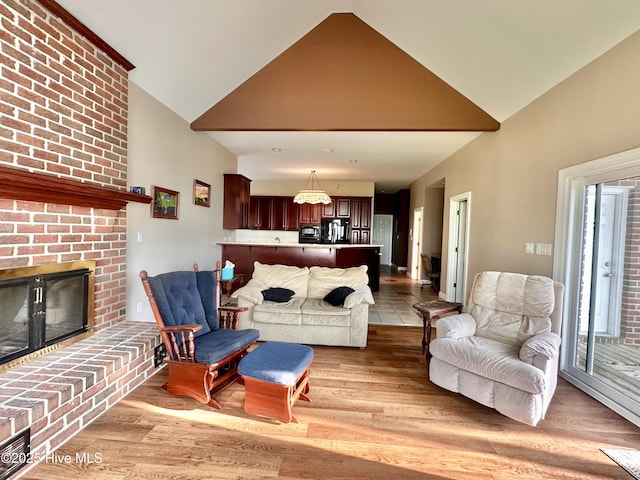 141 Baybreeze Dr, Shiloh, NC 27974 - living room featuring a brick fireplace, light wood-style flooring, and high vaulted ceiling