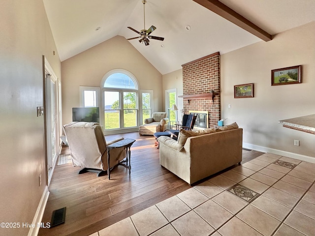 141 Baybreeze Dr, Shiloh, NC 27974 - living area featuring high vaulted ceiling, ceiling fan, a brick fireplace, light tile patterned floors, and baseboards