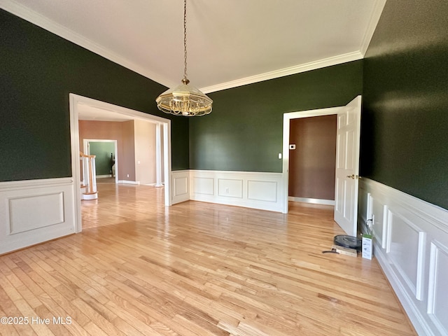 141 Baybreeze Dr, Shiloh, NC 27974 - unfurnished dining area featuring crown molding, a chandelier, wainscoting, light wood-style floors, and a decorative wall