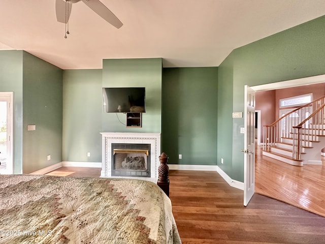 141 Baybreeze Dr, Shiloh, NC 27974 - unfurnished living room featuring wood finished floors, a tile fireplace, baseboards, ceiling fan, and stairs