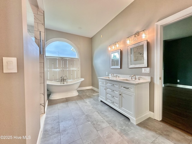 141 Baybreeze Dr, Shiloh, NC 27974 - bathroom with double vanity, a freestanding tub, and baseboards