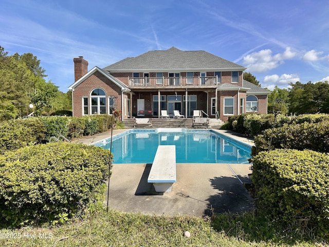 141 Baybreeze Dr, Shiloh, NC 27974 - rear view of house featuring brick siding, a patio area, a chimney, and an outdoor pool