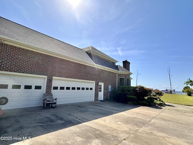 141 Baybreeze Dr, Shiloh, NC 27974 - view of home's exterior with brick siding, concrete driveway, a chimney, and roof with shingles