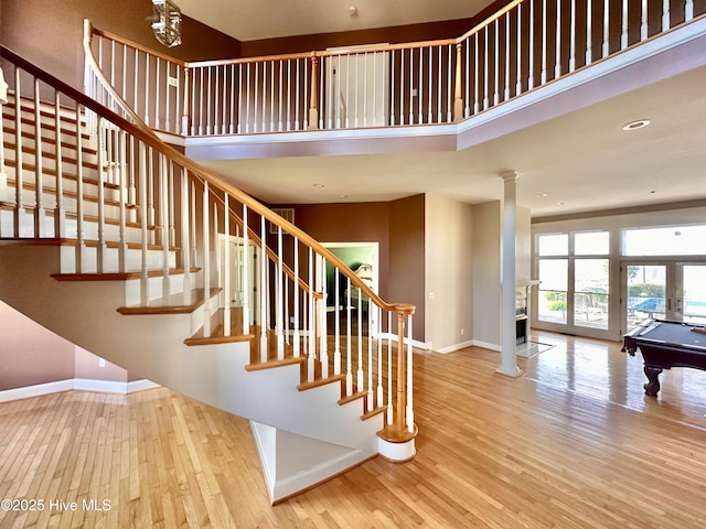 141 Baybreeze Dr, Shiloh, NC 27974 - staircase featuring baseboards, wood finished floors, ornate columns, a towering ceiling, and billiards table