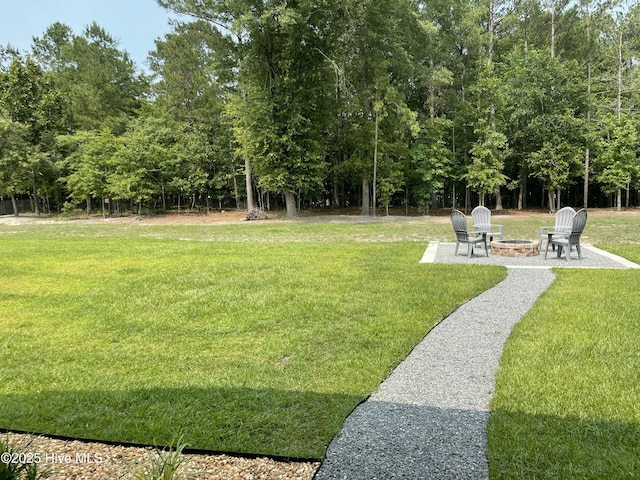 213 Woodsrun St, Raeford, NC 28376 - view of green lawn featuring an outdoor fire pit and a patio