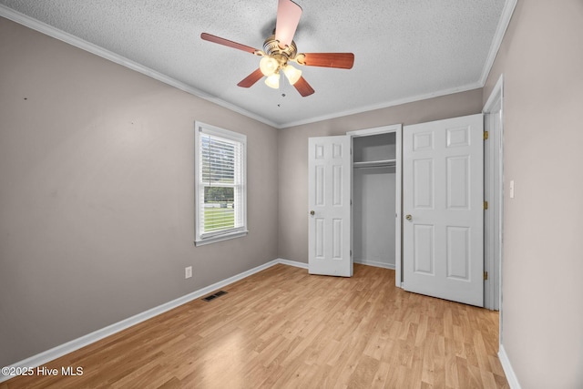 114 Maid Marian Ln, Washington, NC 27889 - unfurnished bedroom with a textured ceiling, light wood-type flooring, crown molding, a closet, and ceiling fan