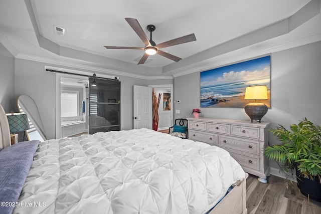 2221 Greaves Ct, Winterville, NC 28590 - bedroom featuring a raised ceiling, a barn door, wood finished floors, a ceiling fan, and ornamental molding
