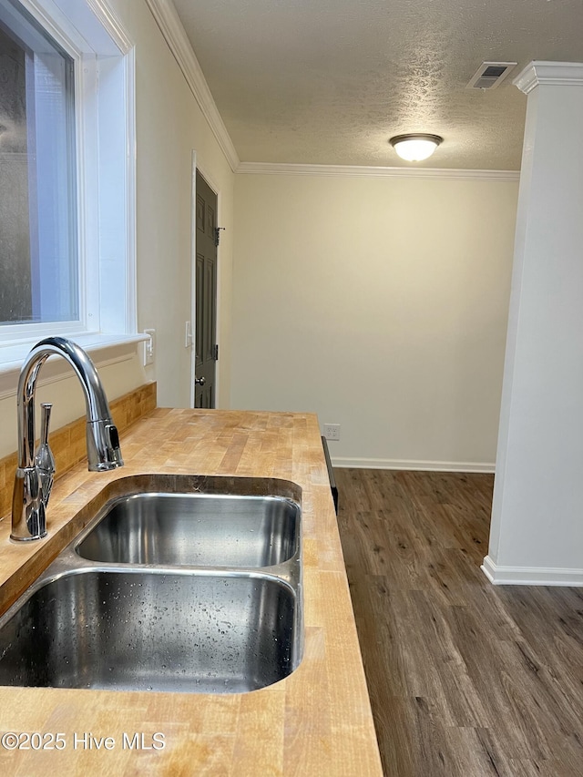 417 S Herman St, Goldsboro, NC 27530 - kitchen with a sink, butcher block counters, wood finished floors, ornamental molding, and baseboards
