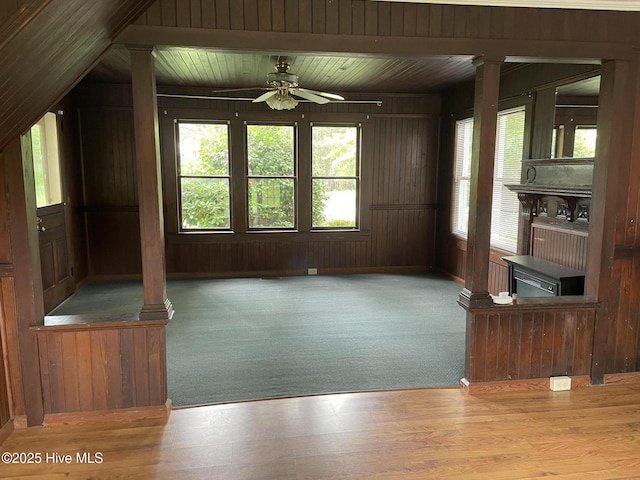 958 Holly Rd, Lakeview, NC 28350 - unfurnished living room with decorative columns, ceiling fan, and wood walls