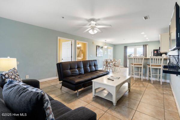 1505 N New River Dr Unit 210, Surf City, NC 28445 - living room featuring light tile patterned flooring, a ceiling fan, and baseboards
