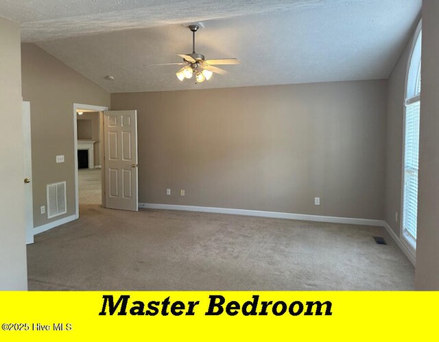 12 Deerwood Ln, Pinehurst, NC 28374 - carpeted spare room featuring vaulted ceiling, a ceiling fan, baseboards, and a textured ceiling