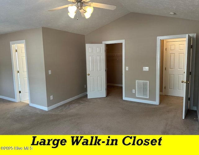 12 Deerwood Ln, Pinehurst, NC 28374 - unfurnished bedroom with carpet floors, vaulted ceiling, baseboards, a walk in closet, and a closet