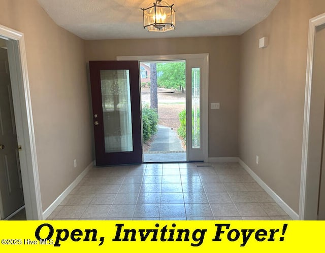 12 Deerwood Ln, Pinehurst, NC 28374 - foyer entrance with baseboards, light tile patterned floors, and a chandelier