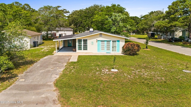 115 NE 66th St, Oak Island, NC 28465 - view of front of property featuring asphalt driveway, an attached carport, a front yard, and french doors