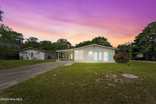 115 NE 66th St, Oak Island, NC 28465 - view of front of property featuring asphalt driveway, french doors, a front lawn, and a carport