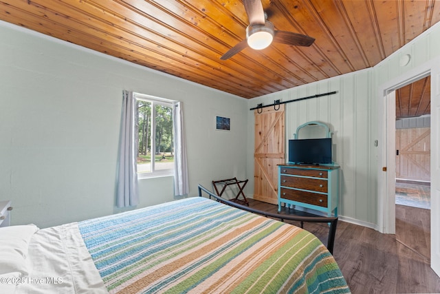 115 NE 66th St, Oak Island, NC 28465 - bedroom with wood ceiling, a barn door, and wood finished floors