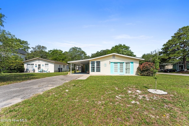 115 NE 66th St, Oak Island, NC 28465 - view of front of property featuring asphalt driveway, a carport, a front yard, and french doors