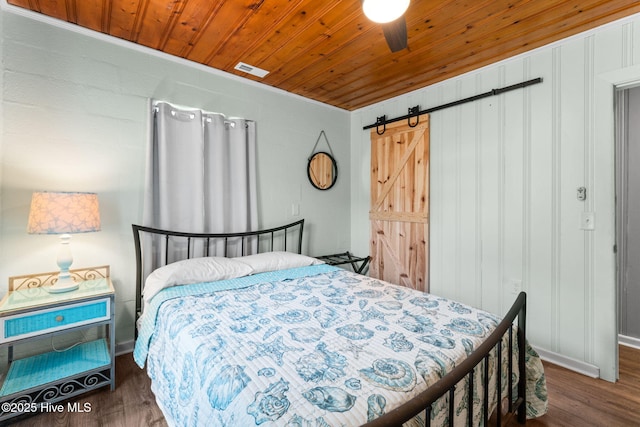 115 NE 66th St, Oak Island, NC 28465 - bedroom with a barn door, wood finished floors, wooden ceiling, ceiling fan, and crown molding