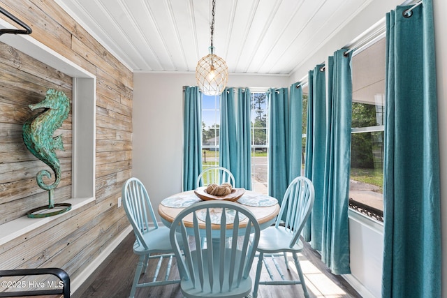 115 NE 66th St, Oak Island, NC 28465 - dining space with wood walls, healthy amount of natural light, wood finished floors, and wood ceiling