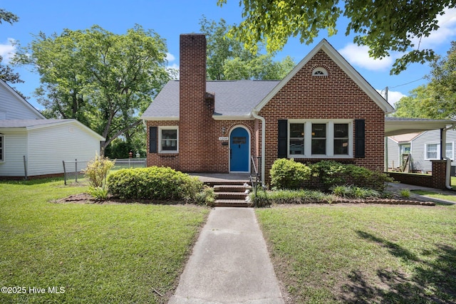 1208 N Bonner St, Washington, NC 27889 - english style home with a chimney, brick siding, and roof with shingles
