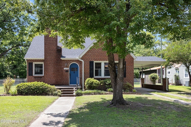 1208 N Bonner St, Washington, NC 27889 - tudor house featuring a chimney, a shingled roof, a carport, and brick siding
