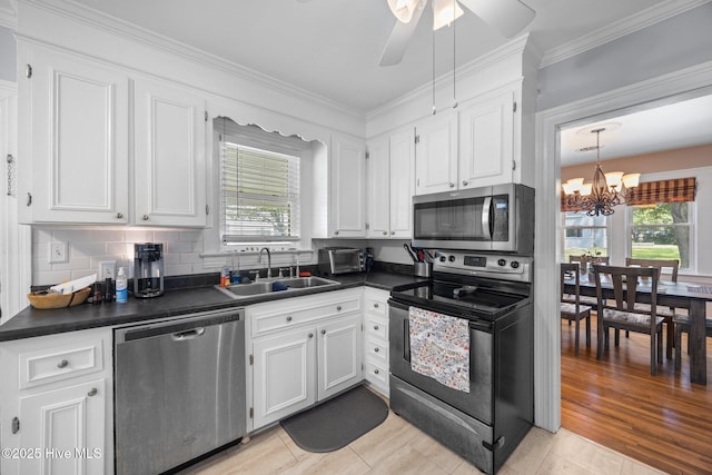 1208 N Bonner St, Washington, NC 27889 - kitchen featuring appliances with stainless steel finishes, a sink, dark countertops, a chandelier, and healthy amount of natural light