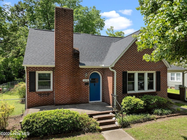 1208 N Bonner St, Washington, NC 27889 - english style home with a chimney, roof with shingles, and brick siding