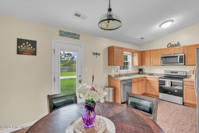 136 Van Riggs Rd, Hubert, NC 28539 - kitchen featuring appliances with stainless steel finishes, lofted ceiling, light brown cabinets, light countertops, and light wood-style flooring