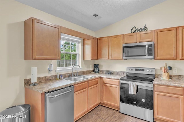 136 Van Riggs Rd, Hubert, NC 28539 - kitchen with stainless steel appliances, light countertops, light wood-style flooring, a textured ceiling, and light brown cabinetry