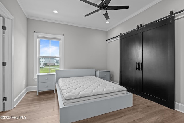 520 Cannonsgate Dr, Newport, NC 28570 - bedroom with a barn door, ornamental molding, light wood-style flooring, recessed lighting, and ceiling fan