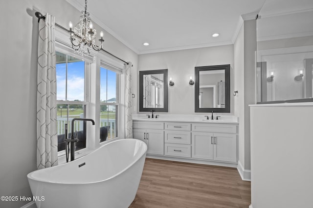 520 Cannonsgate Dr, Newport, NC 28570 - full bathroom featuring double vanity, crown molding, a freestanding bath, wood finished floors, and recessed lighting
