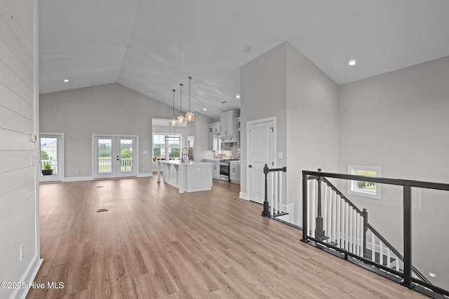 520 Cannonsgate Dr, Newport, NC 28570 - unfurnished living room with high vaulted ceiling, light wood-type flooring, recessed lighting, french doors, and a chandelier