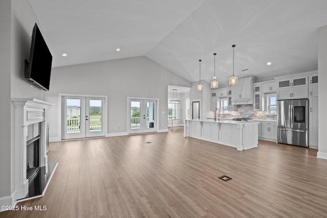 520 Cannonsgate Dr, Newport, NC 28570 - unfurnished living room with french doors, high vaulted ceiling, light wood finished floors, and a premium fireplace