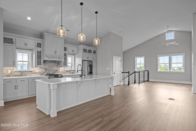 520 Cannonsgate Dr, Newport, NC 28570 - kitchen with stainless steel appliances, light countertops, a center island with sink, wood finished floors, and tasteful backsplash