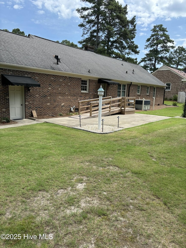 211 Forest Hills Rd NW, Wilson, NC 27896 - back of property with a patio, brick siding, a lawn, and roof with shingles
