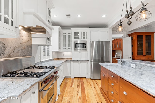 733 Legare Ln SW, Supply, NC 28462 - kitchen with stainless steel appliances, light wood-style floors, ornamental molding, light stone counters, and a sink
