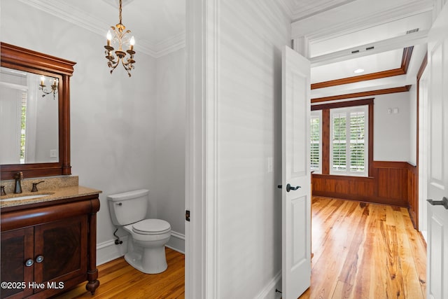 733 Legare Ln SW, Supply, NC 28462 - bathroom featuring wood-type flooring, toilet, vanity, a wainscoted wall, and a chandelier