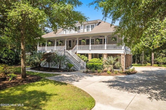 733 Legare Ln SW, Supply, NC 28462 - raised beach house featuring a porch, stairway, driveway, a front yard, and roof with shingles