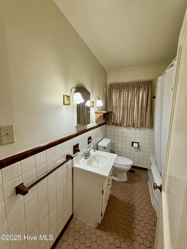 110 N Main St, Colerain, NC 27924 - bathroom with vanity, toilet, tile walls, tile patterned floors, and wainscoting