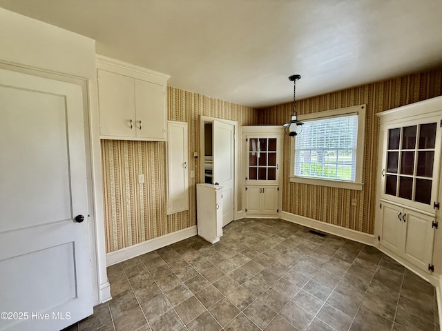 110 N Main St, Colerain, NC 27924 - unfurnished dining area with wallpapered walls, baseboards, and stone finish floors